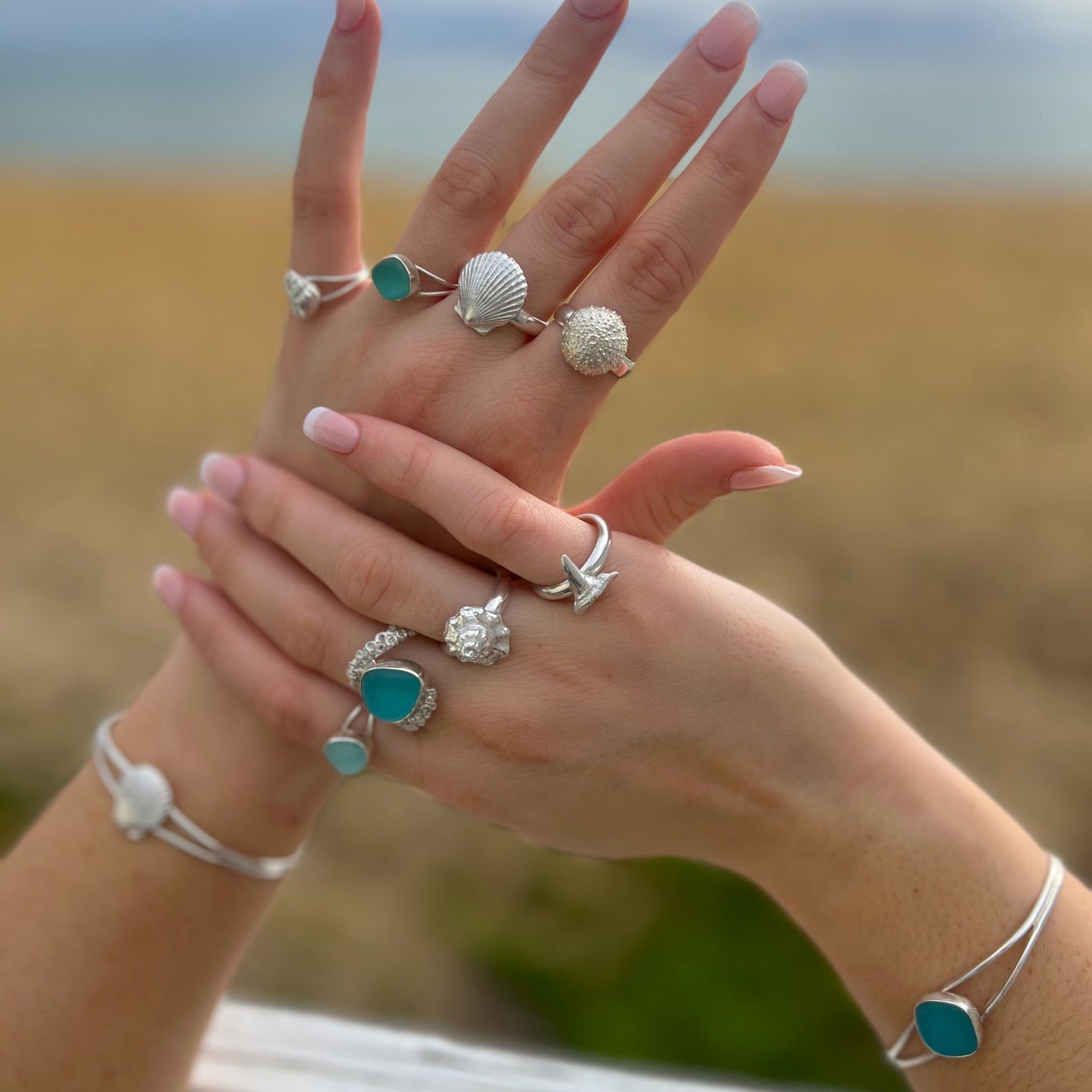 Hands modelling sea glass and cast silver shell rings and bangles by Mornington Sea Glass