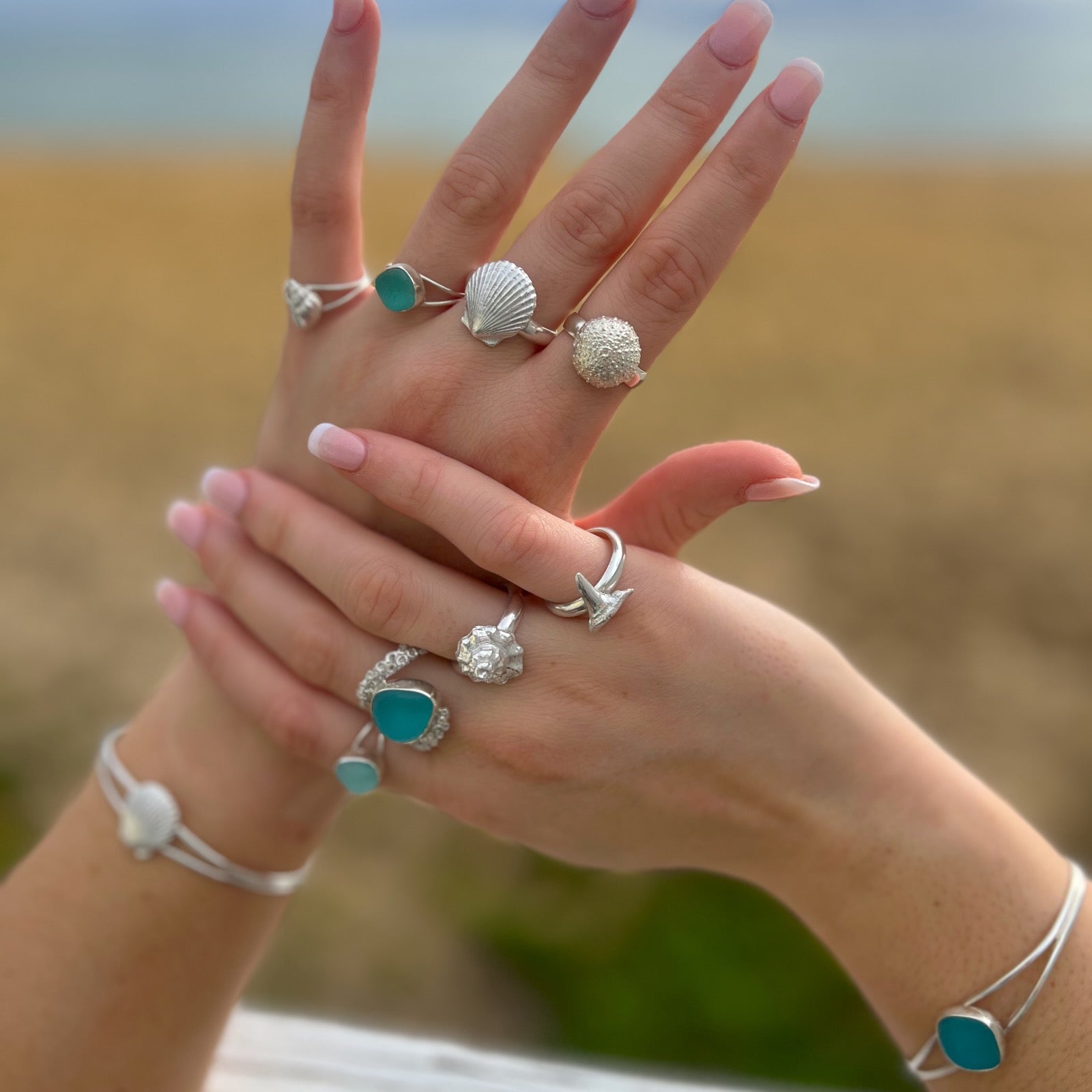 Hands modelling sea glass and cast silver shell rings and bangles by Mornington Sea Glass
