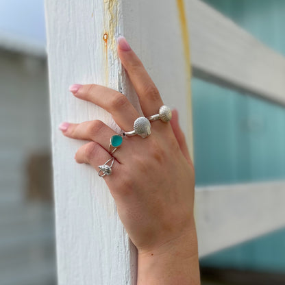 Hands modelling sea glass and cast silver shell rings by Mornington Sea Glass