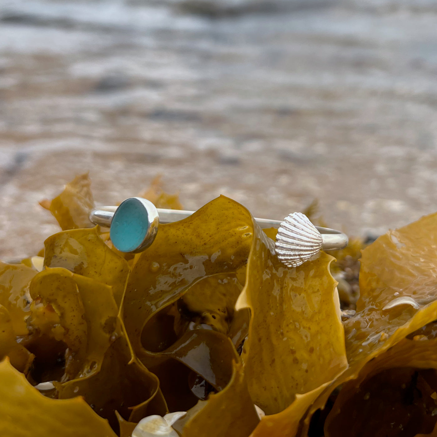 Ocean teal sea glass set in silver cuff and cast shell charm cuff by Mornington Sea Glass.