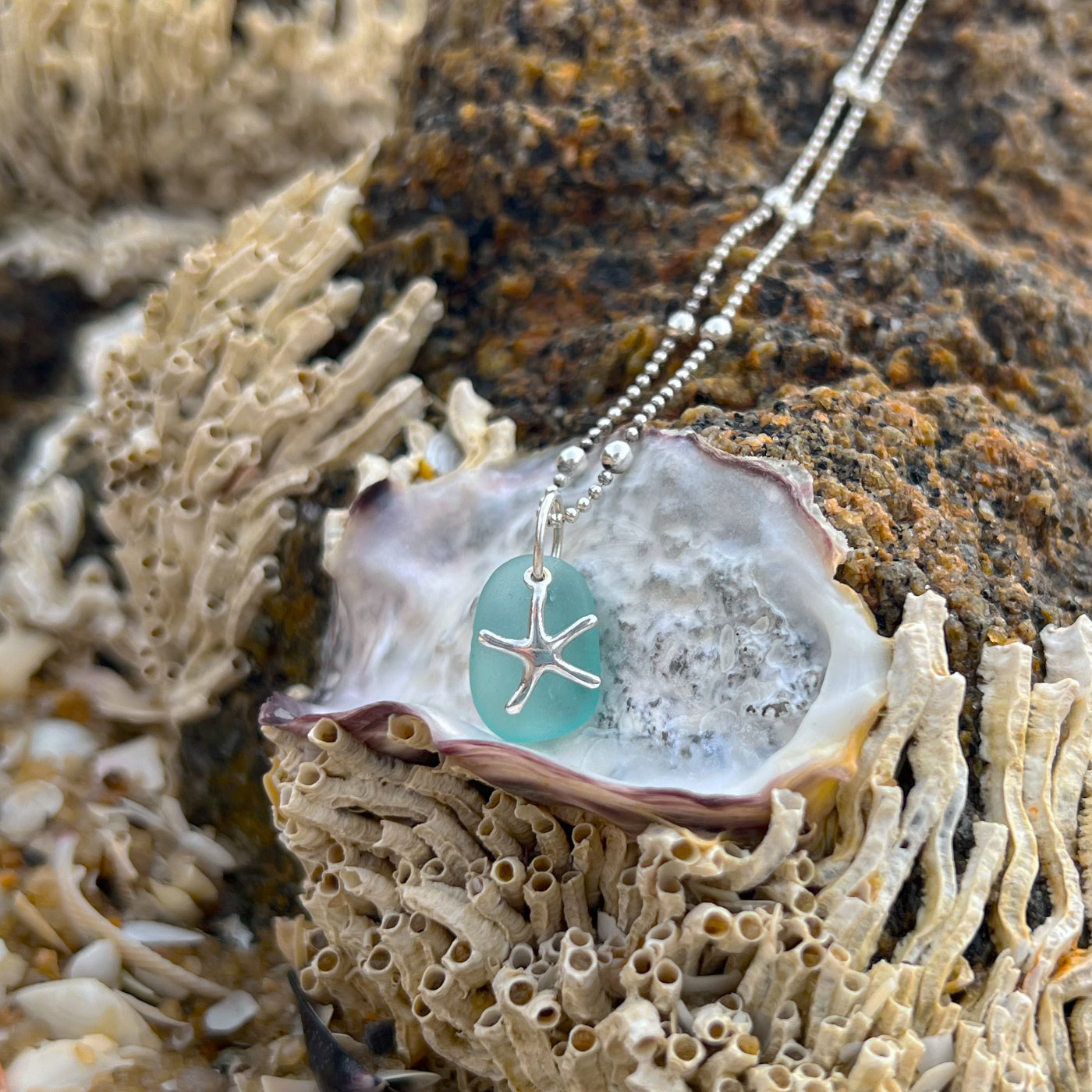 Soft blue sea glass and silver sea star pendant  by Mornington Sea Glass. Hangs on a 40cm sterling silver ball detail chain 